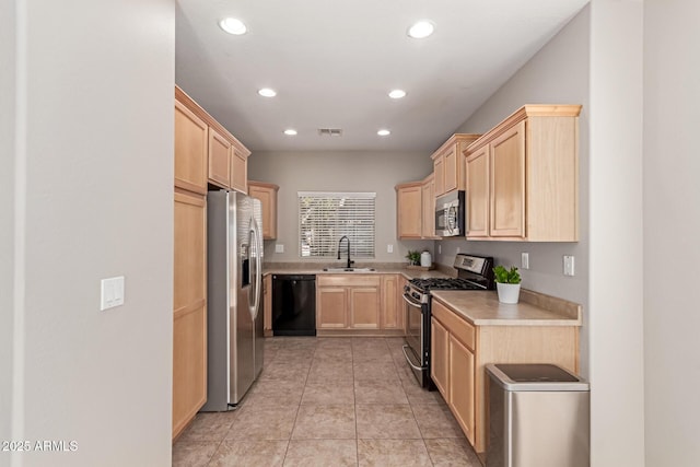 kitchen featuring a sink, visible vents, light countertops, appliances with stainless steel finishes, and light brown cabinetry