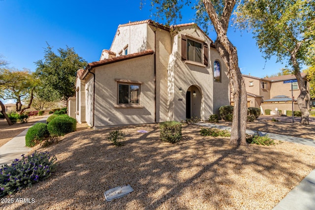 mediterranean / spanish house with a tile roof and stucco siding