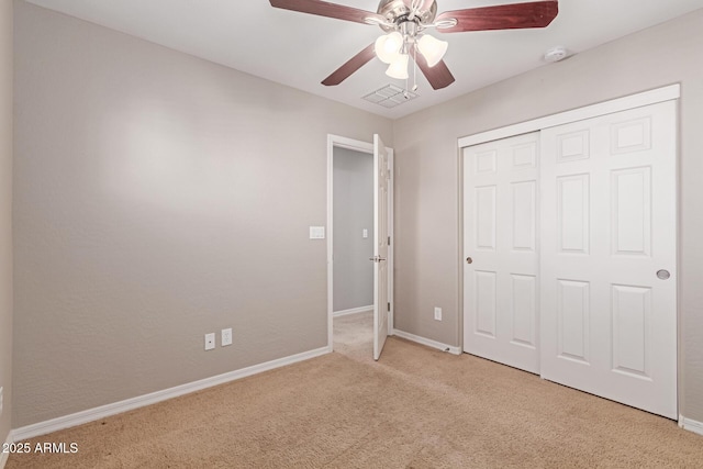 unfurnished bedroom with a closet, light colored carpet, visible vents, and baseboards