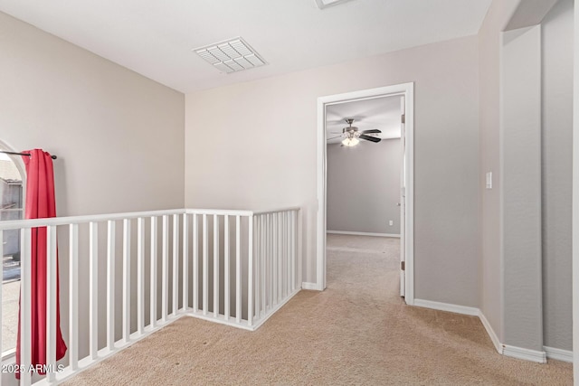 corridor with baseboards, visible vents, and carpet flooring