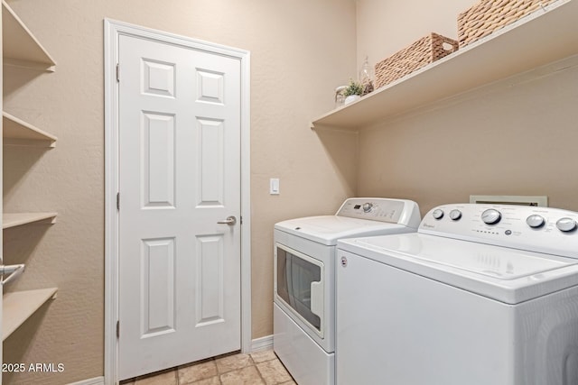 washroom featuring laundry area, washer and clothes dryer, and baseboards