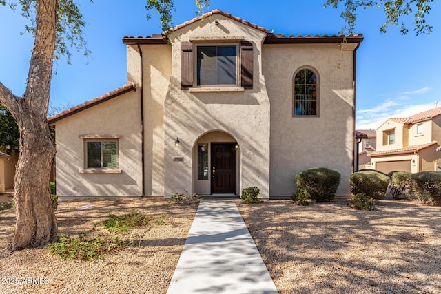 mediterranean / spanish-style home featuring a tiled roof and stucco siding