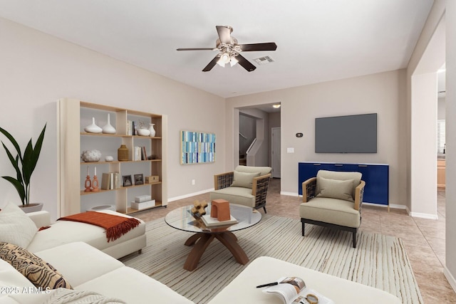 living room featuring ceiling fan, light tile patterned floors, visible vents, and baseboards