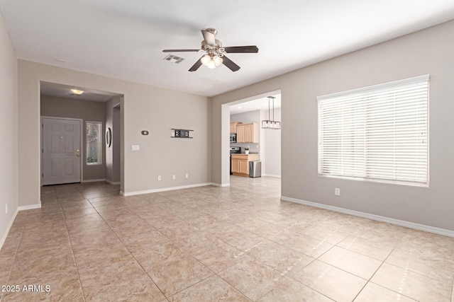 empty room featuring visible vents, ceiling fan, and baseboards