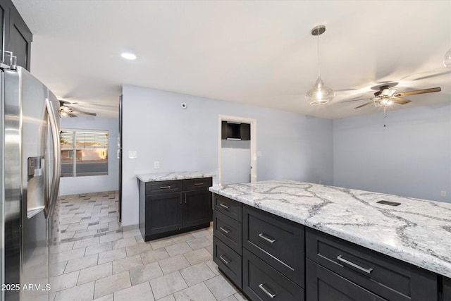 2726 W Meseto Cir, Mesa, AZ 85202 - kitchen with stainless steel fridge with ice dispenser, ceiling fan, pendant lighting, light stone countertops, and dark cabinets