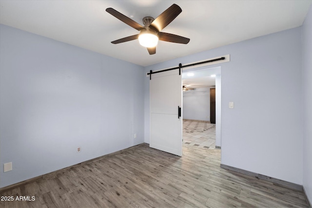2726 W Meseto Cir, Mesa, AZ 85202 - unfurnished room with a barn door, a ceiling fan, and light wood-style flooring