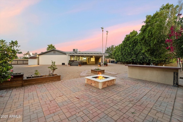 2726 W Meseto Cir, Mesa, AZ 85202 - patio terrace at dusk featuring a patio area, a fire pit, and a hot tub