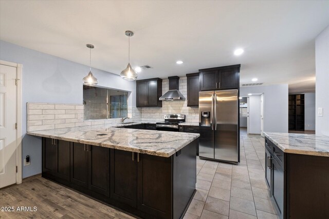 2726 W Meseto Cir, Mesa, AZ 85202 - kitchen with stainless steel appliances, wall chimney exhaust hood, a peninsula, backsplash, and light stone countertops