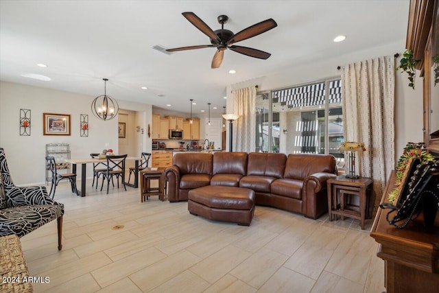 living room with ceiling fan with notable chandelier