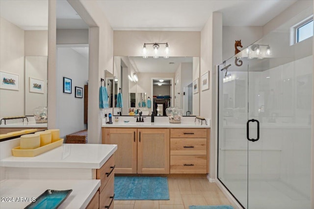 bathroom featuring a shower with shower door and vanity