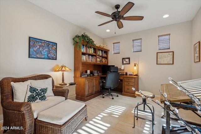 home office with light wood-type flooring and ceiling fan