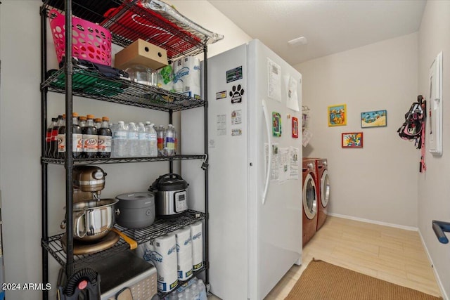 clothes washing area featuring washing machine and clothes dryer and wood-type flooring