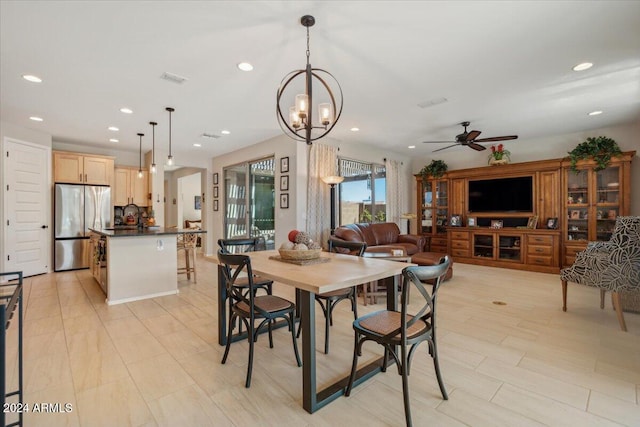 dining room with sink and ceiling fan with notable chandelier