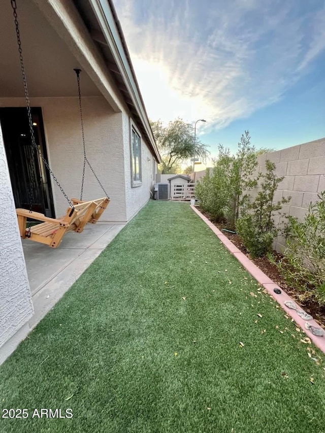 yard at dusk featuring a storage shed