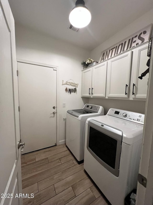 washroom featuring cabinets and separate washer and dryer