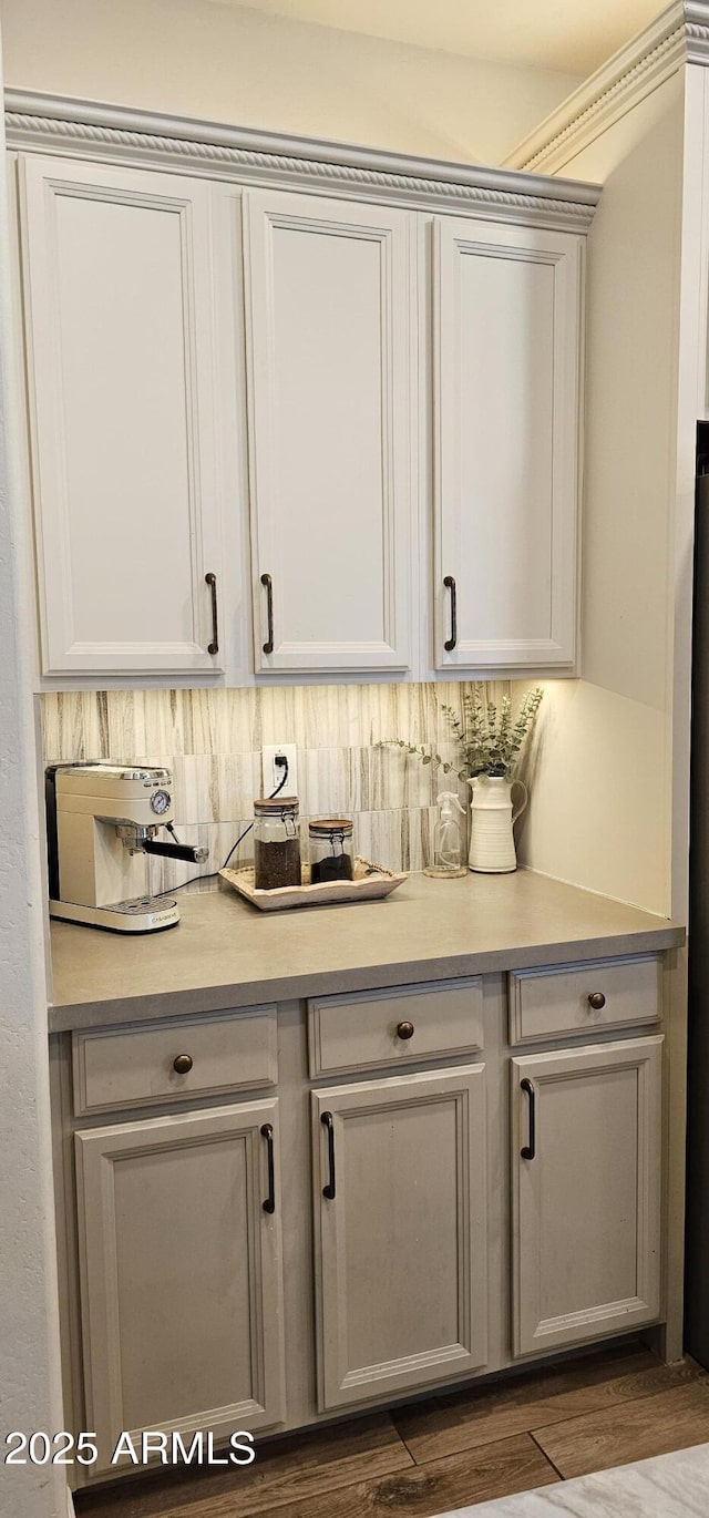 bar featuring decorative backsplash and dark hardwood / wood-style floors