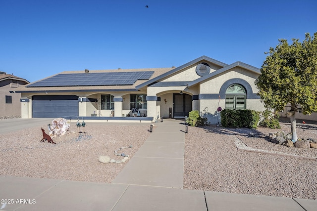 single story home with a garage and solar panels