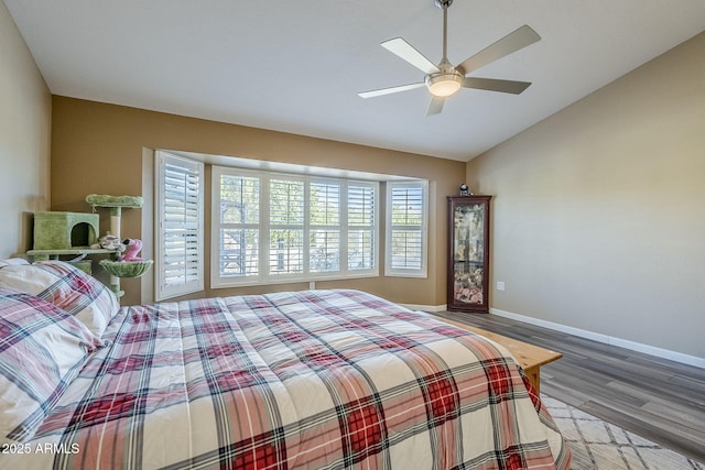 bedroom featuring hardwood / wood-style floors, vaulted ceiling, and ceiling fan