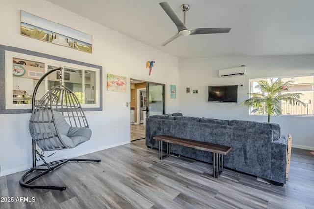 living room with wood-type flooring, lofted ceiling, an AC wall unit, and ceiling fan