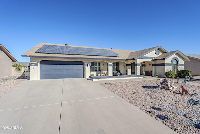 ranch-style home with a garage and solar panels