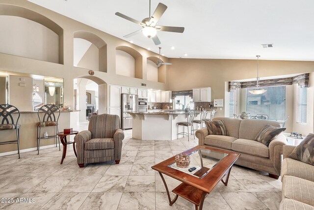 living room with marble finish floor, high vaulted ceiling, visible vents, and a ceiling fan