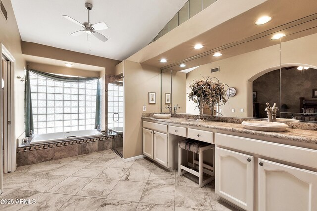 bathroom with double vanity, visible vents, ceiling fan, a garden tub, and a sink