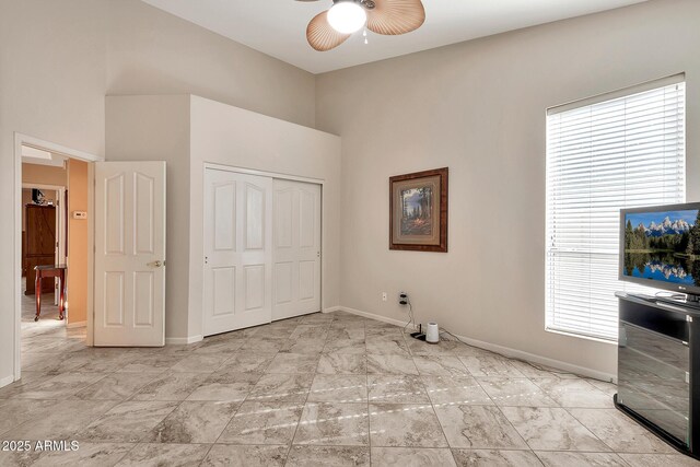 unfurnished bedroom featuring marble finish floor, a closet, and baseboards