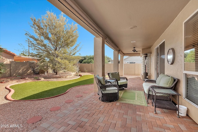 view of patio featuring an outdoor hangout area, a fenced backyard, and a ceiling fan