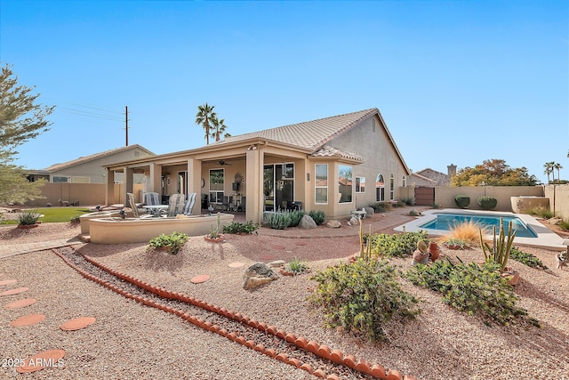 rear view of property featuring ceiling fan, a fenced backyard, a patio, and stucco siding