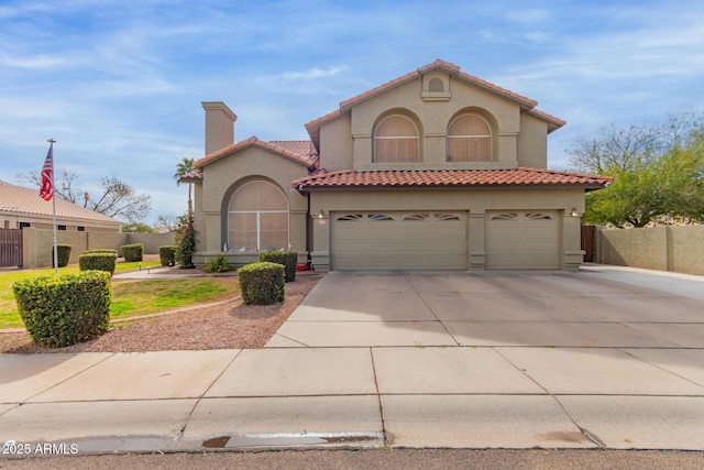 mediterranean / spanish-style home with a garage, driveway, a chimney, and stucco siding