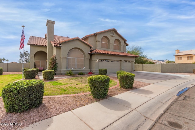 mediterranean / spanish-style house with a garage, fence, a tile roof, driveway, and stucco siding