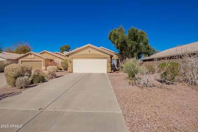 view of front facade with driveway, an attached garage, a tile roof, and stucco siding