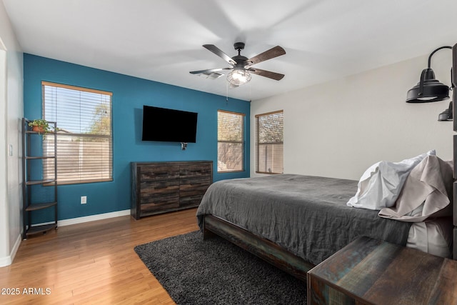 bedroom featuring a ceiling fan, baseboards, and wood finished floors