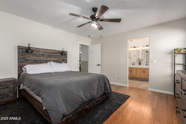 bedroom with ensuite bathroom, ceiling fan, light wood-type flooring, and baseboards