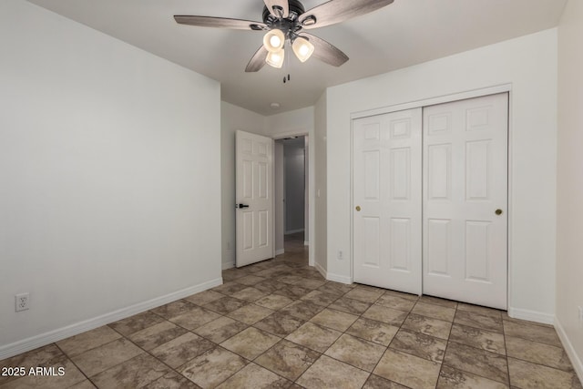 unfurnished bedroom featuring a ceiling fan, baseboards, and a closet