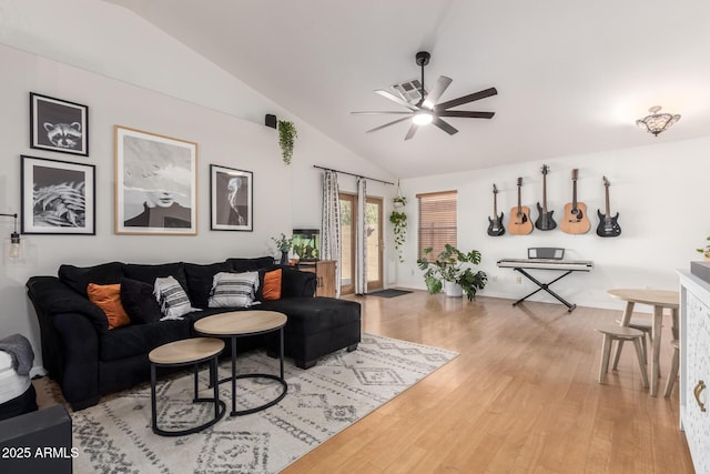 living area with light wood-style flooring, vaulted ceiling, and a ceiling fan