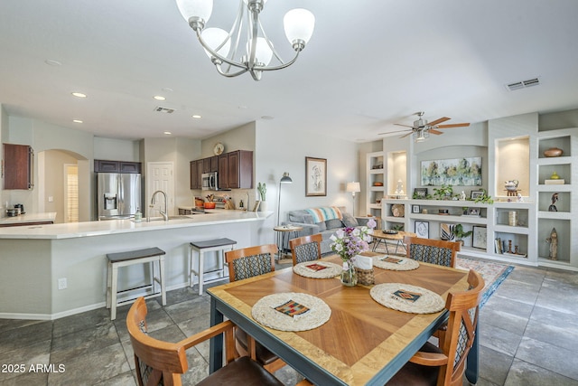 15848 W Calavar Rd, Surprise, AZ 85379 - dining space featuring arched walkways, ceiling fan, a chandelier, recessed lighting, and built in shelves