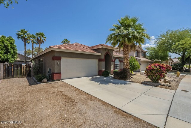 15848 W Calavar Rd, Surprise, AZ 85379 - view of front of home featuring stucco siding, an attached garage, a tile roof, and fence