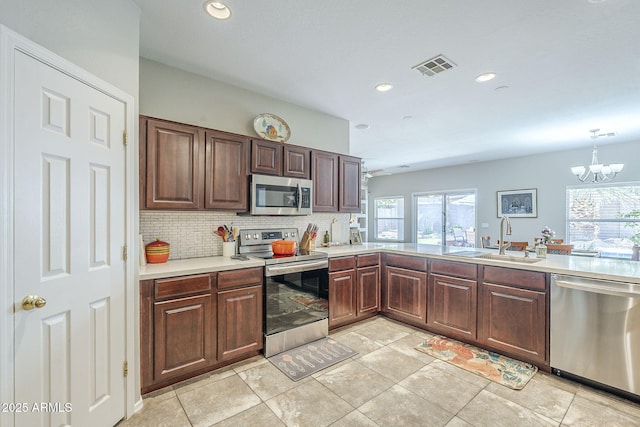 15848 W Calavar Rd, Surprise, AZ 85379 - kitchen featuring stainless steel appliances, a sink, healthy amount of natural light, light countertops, and recessed lighting