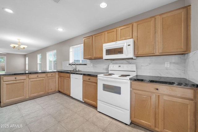 kitchen featuring tasteful backsplash, white appliances, dark stone counters, and sink