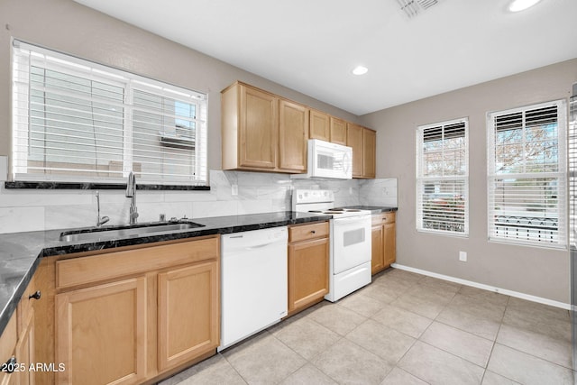 kitchen featuring white appliances, a healthy amount of sunlight, sink, and decorative backsplash