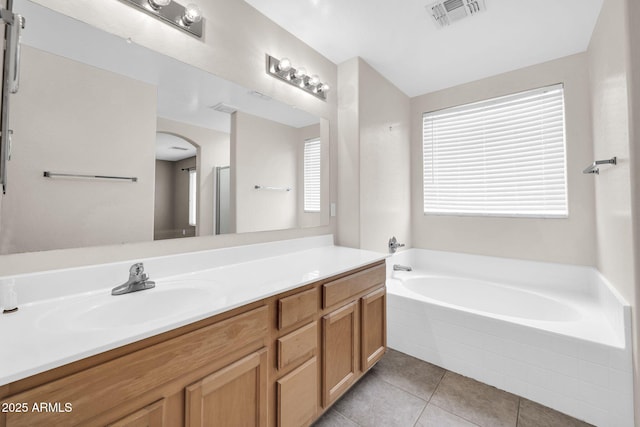 bathroom featuring tile patterned floors, vanity, and tiled tub