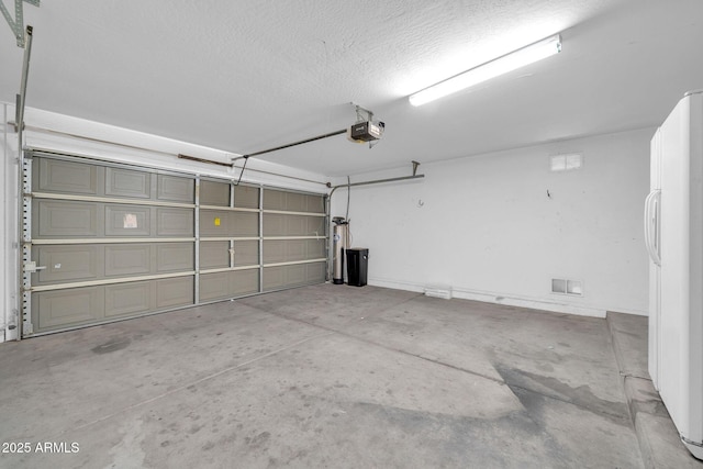 garage featuring a garage door opener and white fridge