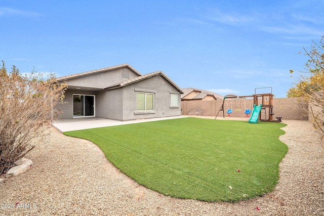 back of property featuring a yard, a patio area, and a playground