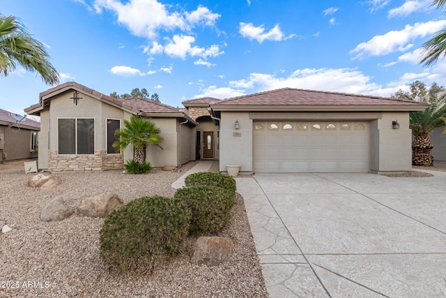 view of front of property featuring stucco siding, a tile roof, stone siding, concrete driveway, and an attached garage