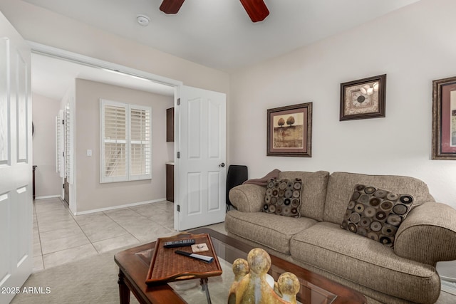 living area with light tile patterned flooring, baseboards, and ceiling fan