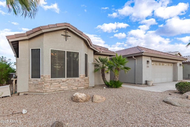 view of front of property with a garage, stone siding, a tile roof, and stucco siding