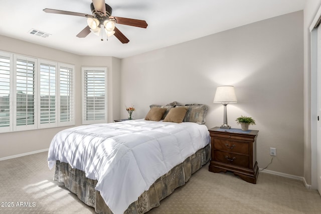 bedroom with ceiling fan, baseboards, visible vents, and light carpet