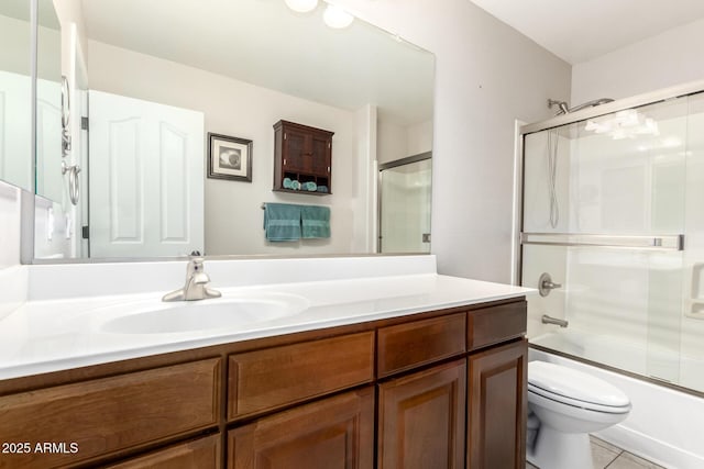 full bath featuring vanity, toilet, and bath / shower combo with glass door