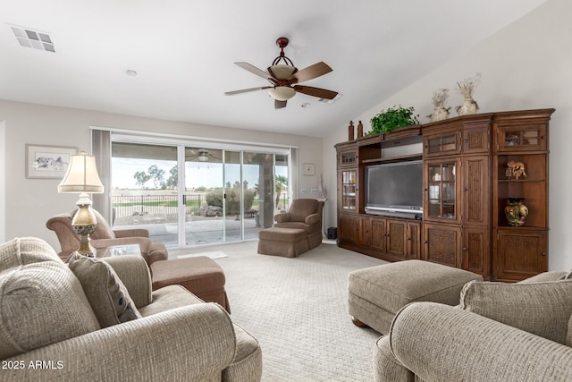 living area featuring visible vents, light carpet, ceiling fan, and vaulted ceiling